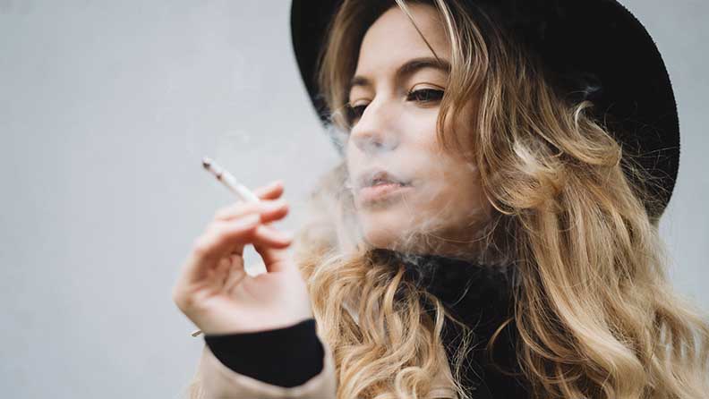 Eine Frau raucht genüsslich eine Zigarette